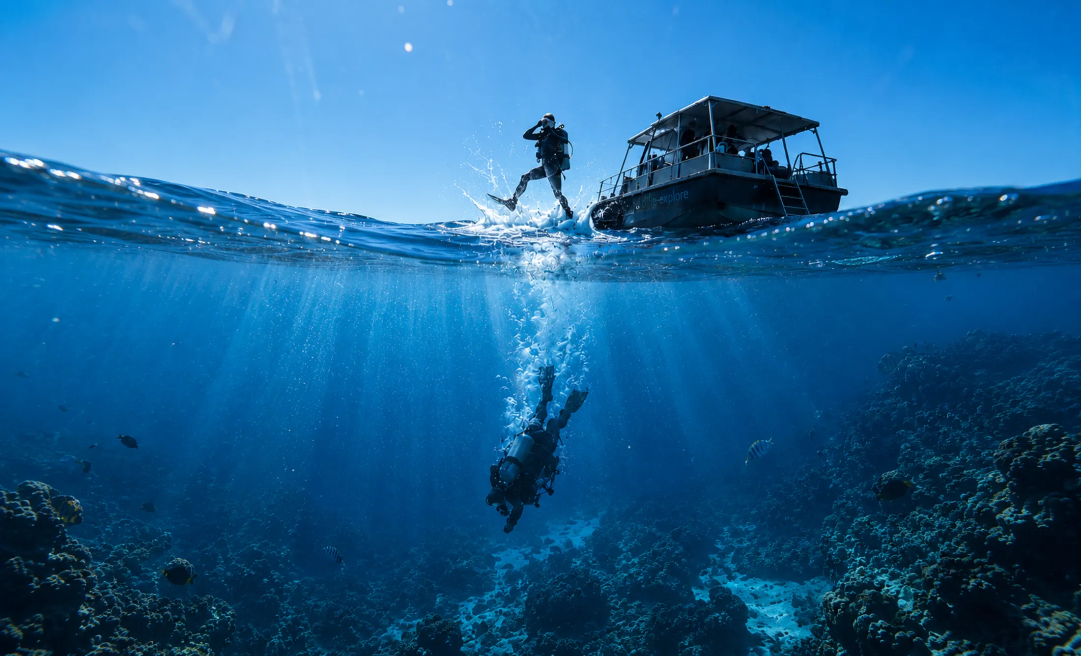A diver stepping off the dive boat into open water